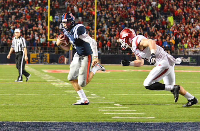 Nov 7, 2015; Oxford, MS, USA; Mississippi Rebels quarterback Chad Kelly (10) carries the ball past Arkansas Razorbacks linebacker Brooks Ellis (51) to score a touchdown in overtime at Vaught-Hemingway Stadium. The Razorbacks won 53-52.